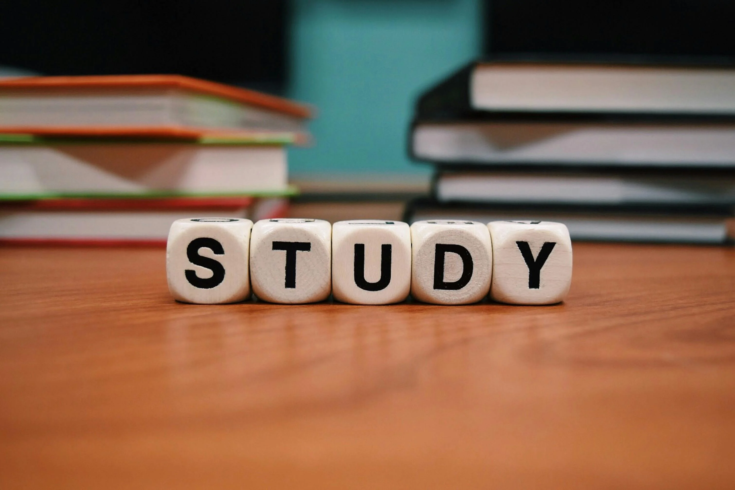 http://桌面以字母骰子排出%20STUDY，後方堆疊多本書籍